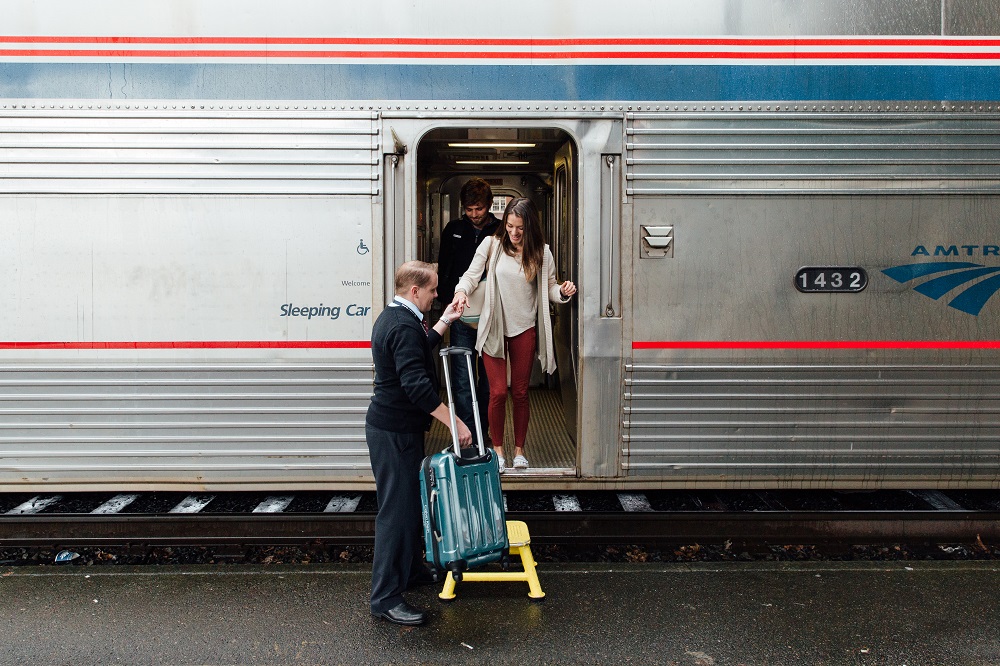 Woman-being-helped-with-luggage-Amtrak